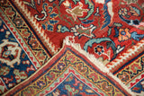 Vintage Mahal rug's cherry red field with scrolling vinery, indigo blue border, and low pile.