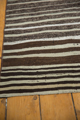 Detail of hand-woven Moroccan Kilim rug with repeating horizontal ivory and rich brown striated bands.