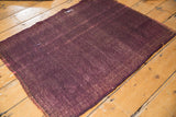 Vintage Turkish Kilim's hand woven texture, highlighting subtle warp and small rewoven foundation in aubergine wine tones.