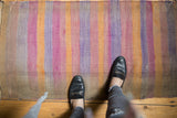 2x4 Vintage Distressed Turkish Kilim Rug Runner with horizontal stripes in faded orange, purple, and beige tones showing wear and color variation