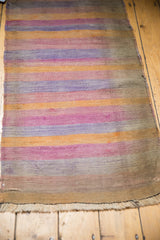 2x4 Vintage Distressed Turkish Kilim Rug Runner with horizontal faded stripes in tangerine, blue, beige, and pink tones showing light wear and fringe edge