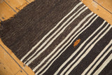 Textured charcoal and ivory striped Kilim edge with orange accent embroidery.