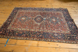 A full perspective view of the vintage Karaja rug with its triple medallion and dark navy border.