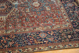 Corner detail of a vintage Karaja rug's geometric motifs in cherry red and indigo blue.