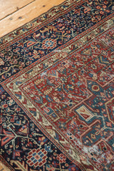 Close view of the Karaja rug's geometric border and time-softened cherry red field.