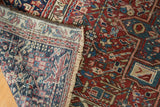 Folded corner of a vintage Persian Karaja rug showing the geometric pile and hand-knotted back.