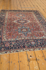 Fringed edge, geometric navy border, and intricate red field of a vintage Karaja rug with light wear.