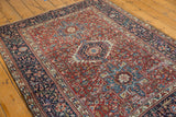Hand-knotted vintage Karaja rug with geometric red field, navy border, and light wear.