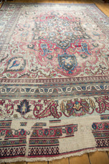 Distressed end of an antique Khorassan carpet showing fringe and ornate floral-geometric borders.