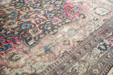 Distressed antique Khorassan rug section with fuchsia, navy floral patterns and Laleh Abassi border.