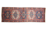 Vintage Karaja runner with brick red, navy blue, and antique ivory stylized geometric medallions.