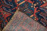 Folded vintage Karaja runner, showing hand-knotted brick red, navy geometric pile and woven foundation.