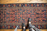 A person's perspective looking down at the vintage Malayer runner's bold Herati pattern.