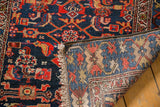 Folded corner of a vintage Malayer runner revealing the hand-knotted back and even pile wear.