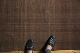 Deep brown hand woven Turkish Kilim rug showcasing subtle warp and weft texture.