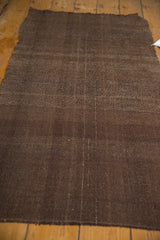 Hand-woven Turkish Kilim texture showing faint structural warp and weft in rich brown.