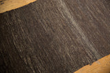 Hand woven Turkish Kilim rug detail, with variegated dark and coffee brown tones.