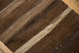 Hand-woven texture of vintage Turkish Kilim rug with striated chocolate brown and ivory stripes.