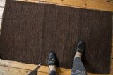 Textured dark chocolate brown hand-woven Kilim rug with natural speckled undyed wool.