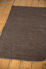 Natural dark chocolate brown undyed wool with speckled hand-woven texture on a Turkish Kilim.