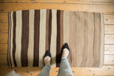 Vertical stripes of ivory, coffee, and dark chocolate with striated abrashes on the Turkish Kilim.