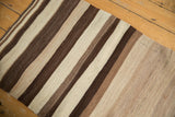 Textured hand-woven vintage Turkish Kilim rug showing striated ivory and brown stripes.