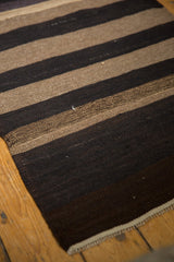 Close-up of vintage Turkish Kilim rug, showing varied coffee brown and sand striped abrashes.