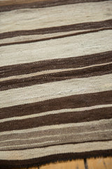 Hand woven Turkish Kilim rug texture with striated ivory and brown horizontal bands.