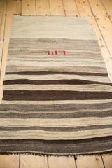 Hand-woven vintage Turkish Kilim showing broad striated bands of ivory, coffee, and dark chocolate.