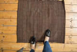 Coffee brown hand-woven Turkish Kilim rug with natural ivory striations and secure edge.