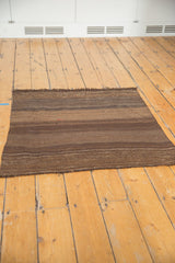 Hand woven Turkish Kilim rug featuring subtle horizontal stripes of natural brown and beige.