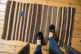 Moroccan Kilim rug with charcoal brown and beige striations, and a charming blue patch.