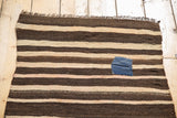 Charming blue patch on a hand woven vintage Moroccan kilim with charcoal brown and beige stripes.