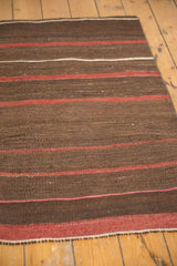 Handwoven Turkish Kilim texture with striated coffee brown, wine red, and ivory stripes.