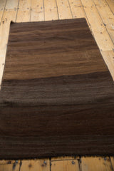 Striated horizontal bands of coffee brown and dark chocolate on hand-woven Turkish kilim.
