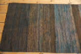Detailed texture of hand-woven natural wool on a vintage Turkish Kilim, khaki and slate gray.