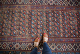 Antique Kuba runner with repeating geometric floral motifs and deep red, navy, blush borders.