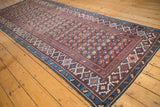 Intricate repeating floral field and geometric borders on this Antique Kuba runner in navy, red, ivory.