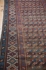 Close-up of antique Kuba runner's staggered floral pattern and geometric border in navy, blush, and wine.