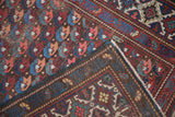 Antique Caucasian Kuba runner's distinct repeating floral motifs, geometric border, and visible foundation.