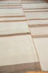 Vintage Turkish kilim detail: ivory panel, pale brown stripe, and terracotta patchwork stitching.
