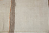 Close-up of the vintage Turkish kilim's banded ivory, brown, and terracotta stitches.