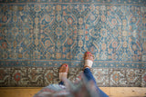 Distressed Malayer border with infinite vine and colorful flower motif, blue Herati field.