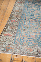 Distressed vintage Malayer runner corner, with infinite vine border and sky blue Herati patterns.