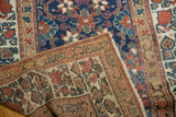 Vintage Kurdish runner corner showing hand-knotted weave, fringe, and navy, red Veramin pattern.