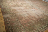 Distressed vintage Oushak rug with moss green border patterns and muted blush field.