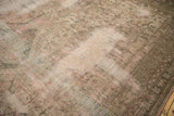 Diagonal close-up of hard-worn Oushak carpet, highlighting faded patterns and exposed foundation.