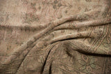 Detail of the hard-worn texture and faded colors on the vintage Oushak rug.