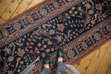 Overhead view of a vintage Persian Mehreban runner's bird and floral patterns.