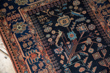 Detail of terracotta and blue bird motifs on the vintage Mehreban runner's navy field.